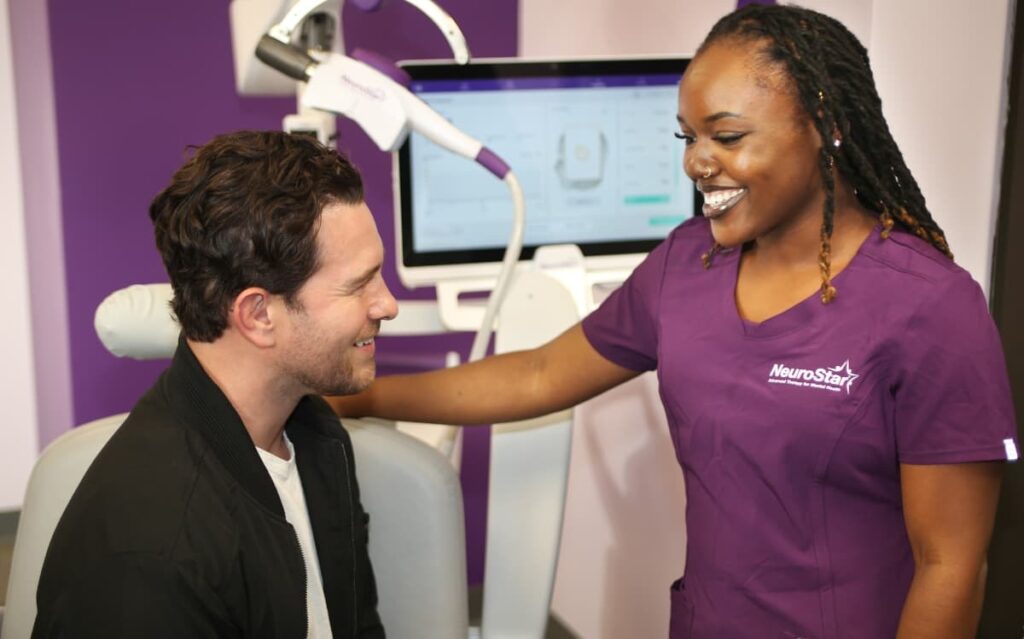 What Are the Signs that TMS is Working? 1 A smiling patient and NeuroStar technician , What Are the Signs that TMS is Working? , sharing a positive moment post-session.